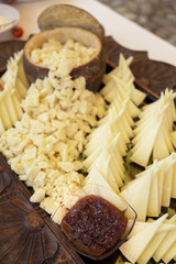 presentazione elegante di formaggio tagliato a cubetti abbinato a marmellata, dentro un vassoio di...