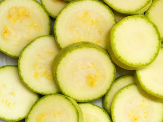 A lot of fresh raw zucchini cut into rings top view, close up, vegetarian raw food texture for a background
