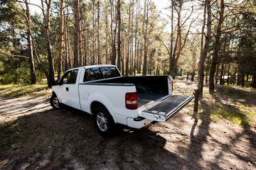 white pickup car with opened truck in forest © LIGHTFIELD STUDIOS