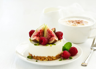 Delicious New York cheesecake with fresh figs and raspberries. close-up.