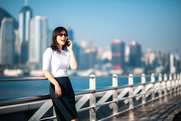 Business woman talking on the phone in Hong Kong waterfront