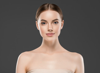 Beautiful woman face skin closeup portrait over gray background with healthy skin and hair
