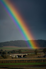 Regenbogen seitlich eines Dorfes