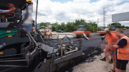 A paver finisher, asphalt finisher or paving machine placing a layer of asphalt during a repaving...