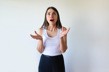 Shocked emotional lady looking up and gesturing hands. Surprised student with open mouth not...