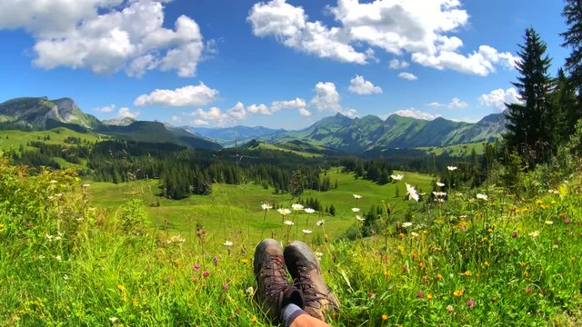 Summer time mountain nature panoramic landscape near Habkern, Switzerland. Hikers trekking boots at foreground