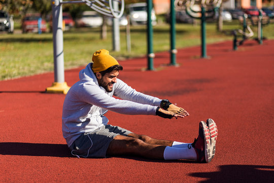 Fit man wearing hoodie stretching before training - Powered by Adobe