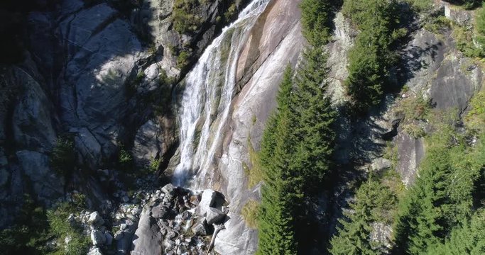 Waterfall on rock wall. Natural park of the Val di Mello, Valtellina, Italian Alps. This valley is famous for sport climbing. Aerial shot made with drone.
