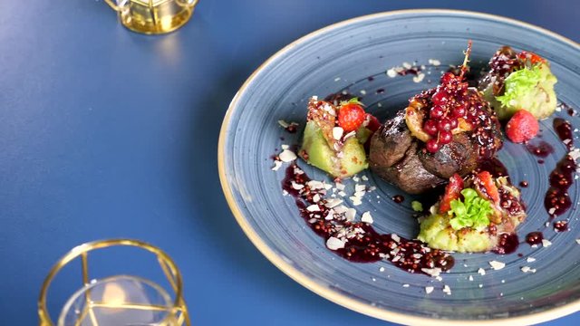 Top view slide footage on grilled steack beef meat on a plate with sweet berries