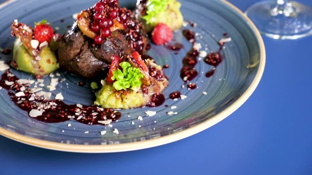 Beef meat steack with sweet berries on a plate on restaurant table