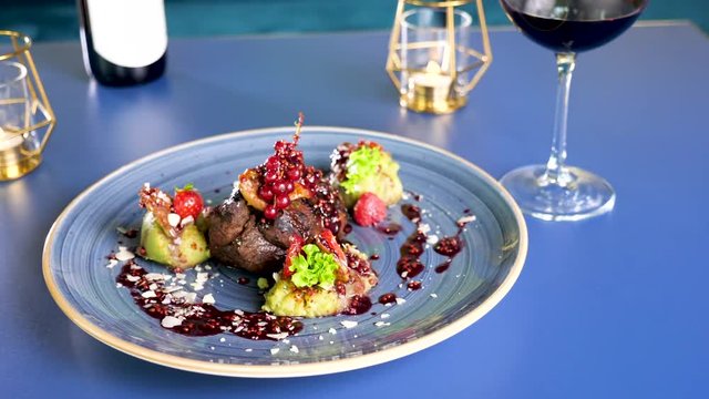 Plate with healthy and delicious grilled beef steack with sweet berries on a plate on table in restaurant