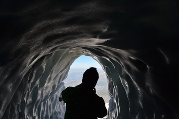Grotte de Glace de La Grave Hautes-Alpes, touriste de dos qui prend une photo du paysage depuis le...