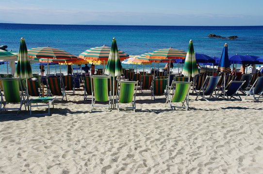 Parasole i leżaki na plaży Grotticelle, Kalabria, Włochy