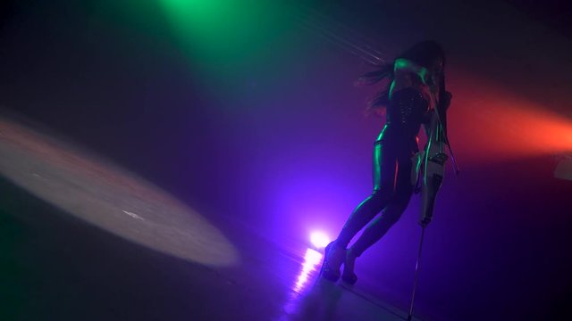 Cellist with electronic cello performs on stage.