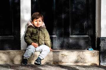 Baby boy sitting on the doorsill