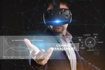 Business, Technology, Internet and network concept. Young businessman working in virtual reality glasses sees the inscription: Change management