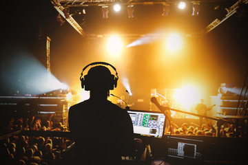 Sound manager on rock concert, silhouette opposite stage light