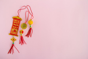 Traditional Vietnamese and Chinese New Year decorations red and golden colors on a pink background, top view.