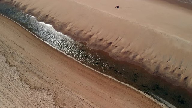La bajada de la marea deja r&iacute;as en las playas de Huelva.