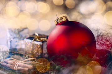 Rote Christbaumkugel mit Weihnachtsdekoration