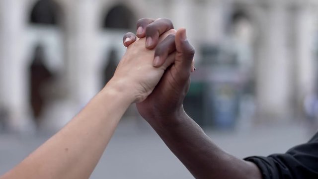 close up on interracial love white woman's hand intertwining with black man hand-slow motion