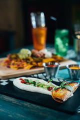 Mexican food concept: tortilla chips, guacamole, salsa, chilli with beans and fresh ingredients in a restaurant.