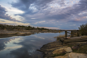 Beautiful evening view, sea water, rocky landscape, clouds and reflection, Kumlinge, Aland islands,...