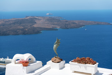Seahorse as decoration of house roof with volcanic crater on a background, Santoini island, Greece