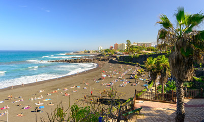 Touristen beim Sonnenbaden am Strand von Puerto de la Cruz auf der kanarischen Insel Teneriffa -...