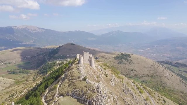 AERIAL: drone flying over the mountains towards the castle of Rocca Calascio, Abruzzo, Italy, in a sunny day.