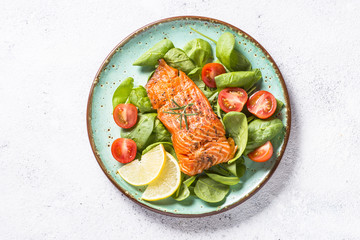 Baked salmon fish fillet with fresh salad top view. - obrazy, fototapety, plakaty