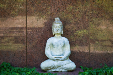 Buddha vor einer Grabsteinplatte aus Marmor