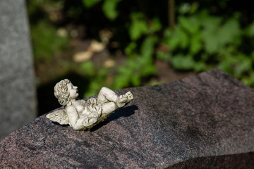 Kleiner Engel liegt gemütlich auf einem Stein