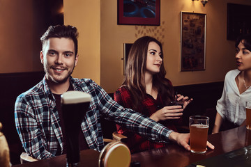 Group of happy multiracial friends resting and talking at bar or pub.
