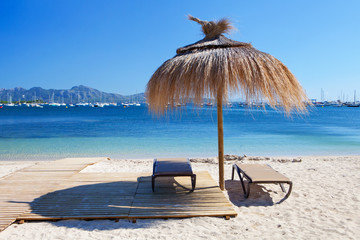 Chairs and umbrella on the beach in Port de Pollenca, Majorca, Spain