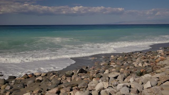 Beautiful waves on sandy beach on Sicili, Italy. Sunny day on the beach.