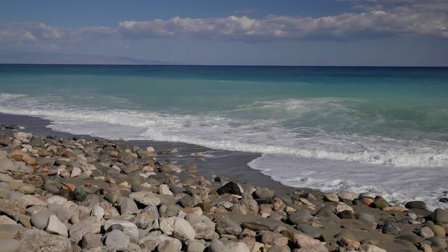 Beautiful waves on sandy beach on Sicili, Italy. Sunny day on the beach.
