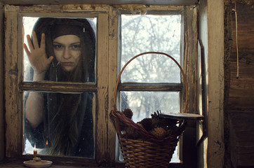 monstrous witch scratches and scrapes at the window of the village hut on a winter day in the hope of intimidating the inhabitants