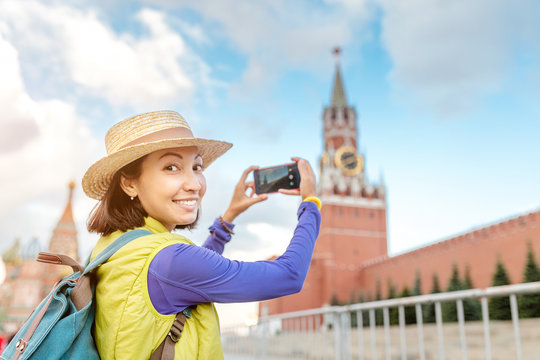 Young traveler woman taking photo using her smartphone on Red Square in Moscow, Russia