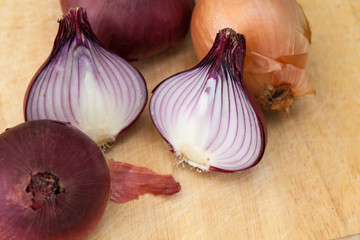 Rote und braune Zwiebeln geteilt auf dem Schneidebrett