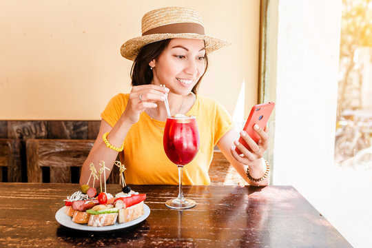 Traveler woman drink sangria and eating tapas in spanish cafe