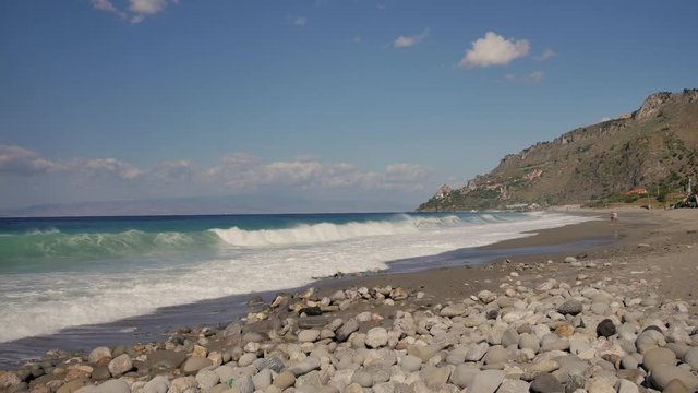 Beautiful waves on sandy beach on Sicili, Italy. Sunny day on the beach.