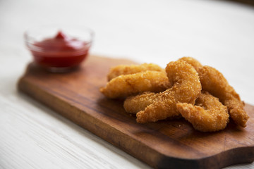 Fried shrimps tempura with sauce on rustic wooden board, side view. Close-up.