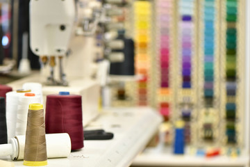 Spools of colored thread in the foreground and blurred in the background