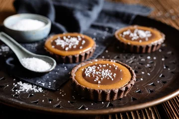 Rolgordijnen Chocolate caramel tartlets studded with salt © noirchocolate