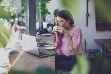 Side view of young businesswoman sitting at table in coffee shop