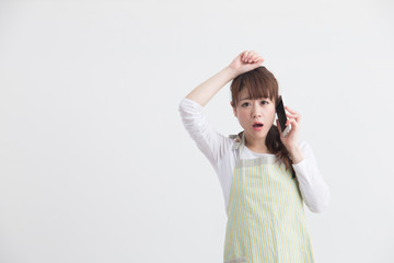 Naklejka premium エプロン姿の女性・スマホ・白バック
