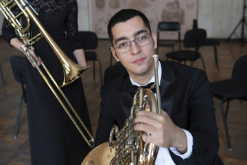 French horn player. Hornist playing brass orchestra music instrument.