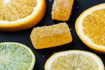 Marmalade next to citrus slices. Lemon, lime, orange.
