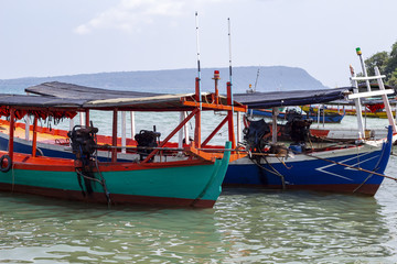 Colorful wooden boat in Cambodia. Koh Rong island seaside view with coral beach and wooden boat.